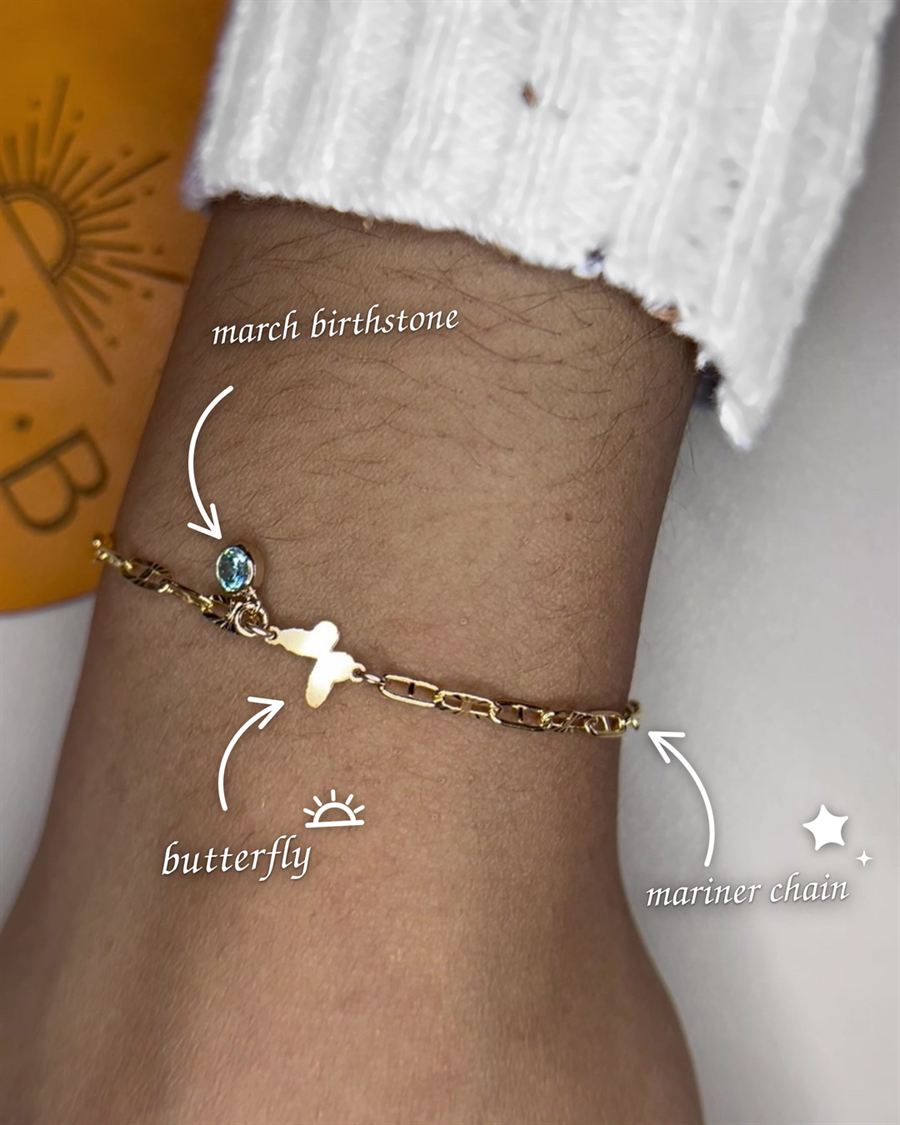 A dainty gold bracelet with a butterfly charm.