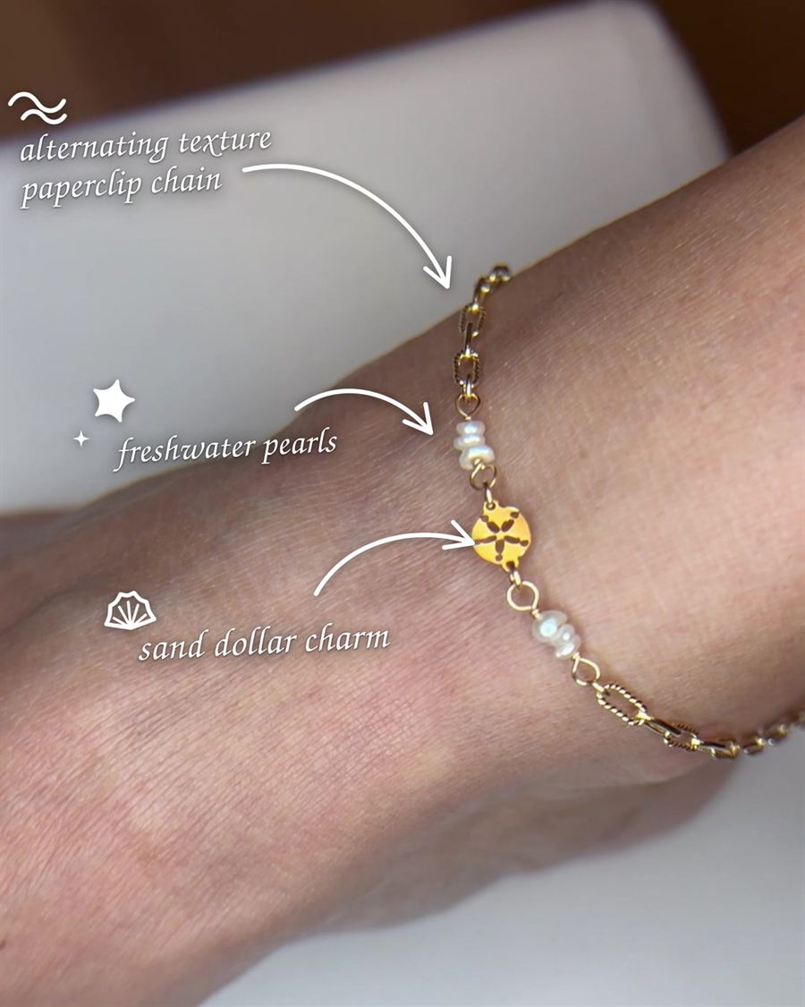 A gold bracelet with a sand dollar charm.